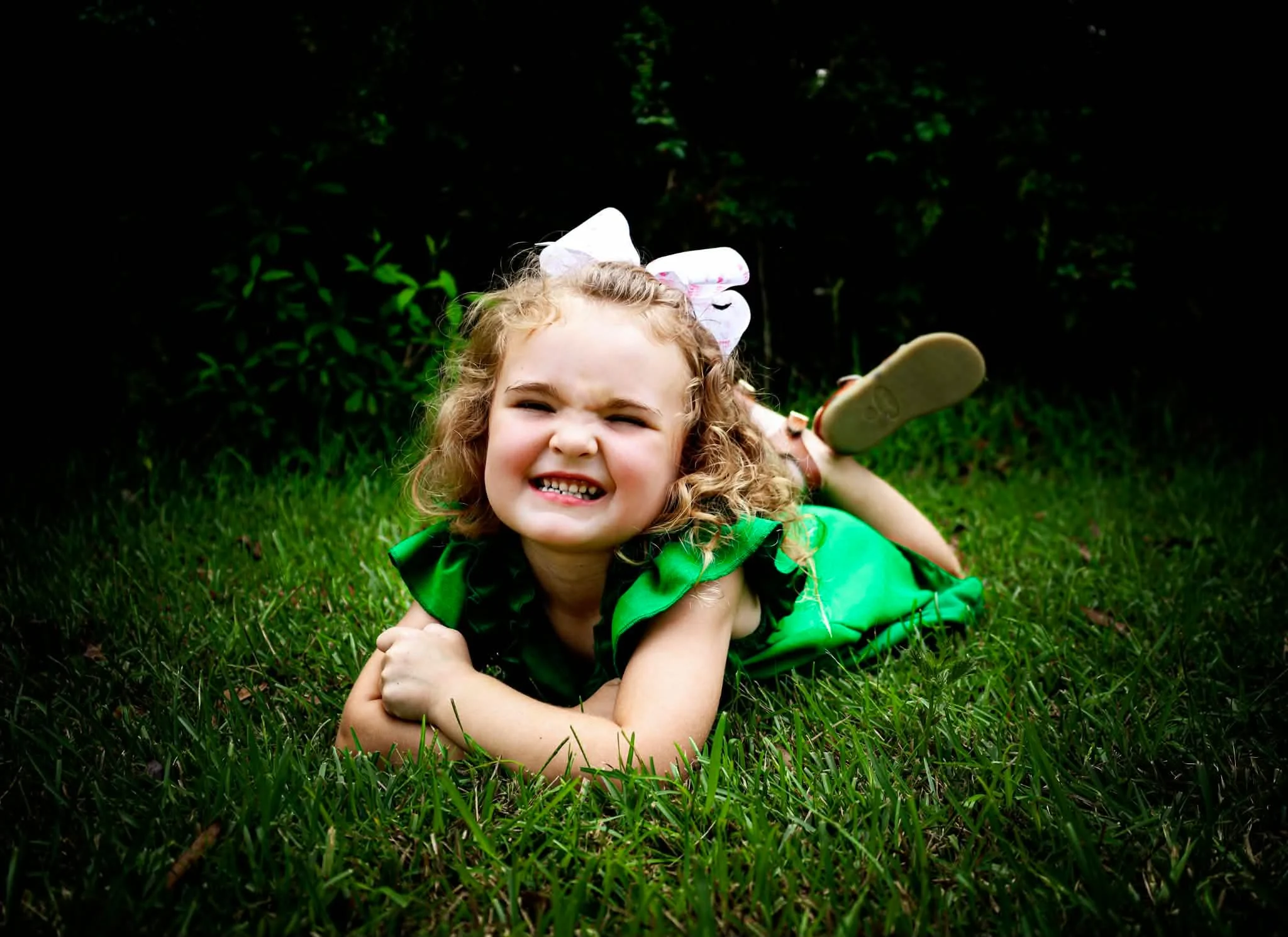 Smiling child lying in the grass during an R3H Photography session